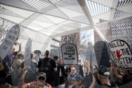 Activists Gather At NYC AIDS Memorial And March To Tesla Dealership For 38th Anniversary Of ACT UP To Protest DOGE Cuts