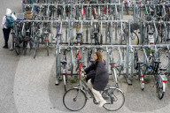 Cyclist Rides Past Bike Racks