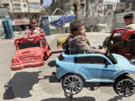 Gaza children playing amidst tents and rubble
