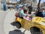 Gaza children playing amidst tents and rubble