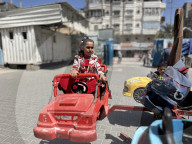 Gaza children playing amidst tents and rubble