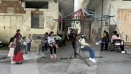 Gaza children playing amidst tents and rubble