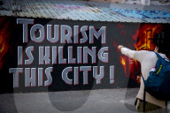  Anti-Tourism Graffiti In Barcelona Draws Tourists Despite Local Discontent