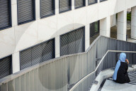 Woman With Headscarf On Staircase Near Office Building