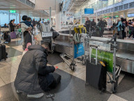 Travelers At A Baggage Carousel At Munich Airport