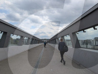 Cyclist And A Pedestrian Crossing A Bridge