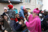Pierbattista Pizzaballa, the Latin Patriarch of Jerusalem, greets people as he arrives to attend Christmas celebrations in Bethlehem, in the West Bank