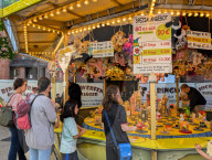 Visitors Enjoy The Auer Dult Fair At Mariahilfplatz In Munich