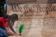 People sign giant U.S. Constitution premable outside White House