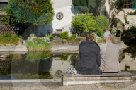 Elderly Couple Sitting By The Water
