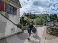 Two Seniors Crossing Bridge With Wheelchair