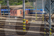 Track Labourer Crossing Rails At Station