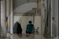 Two Young Men Sitting Quietly In A Passageway