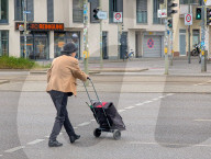 Senior Pedestrian With Shopping Trolley Crossing Street
