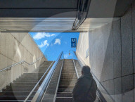 Senior At Escalator Exit At Subway Station