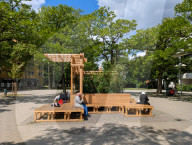 Women Sitting On Wooden Seating Structure In Munich Park