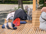 Women Sitting On Wooden Seating Structure In Munich Park