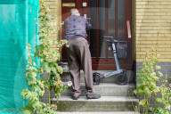 Elderly Man Entering Home With Walker Support