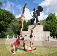 Australia's Head First Acrobats perform the feats of the ancient Greek Gods on the Archilles statue in Hyde Park, London, UK.