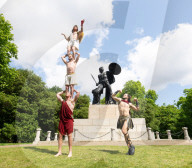 Australia's Head First Acrobats perform the feats of the ancient Greek Gods on the Archilles statue in Hyde Park, London, UK.