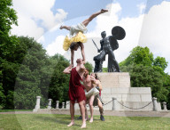 Australia's Head First Acrobats perform the feats of the ancient Greek Gods on the Archilles statue in Hyde Park, London, UK.