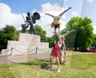 Australia's Head First Acrobats perform the feats of the ancient Greek Gods on the Archilles statue in Hyde Park, London, UK.