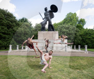 Australia's Head First Acrobats perform the feats of the ancient Greek Gods on the Archilles statue in Hyde Park, London, UK.