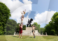 Australia's Head First Acrobats perform the feats of the ancient Greek Gods on the Archilles statue in Hyde Park, London, UK.