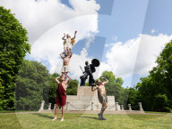 Australia's Head First Acrobats perform the feats of the ancient Greek Gods on the Archilles statue in Hyde Park, London, UK.