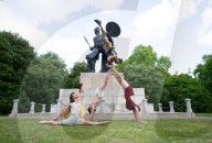 Australia's Head First Acrobats perform the feats of the ancient Greek Gods on the Archilles statue in Hyde Park, London, UK.