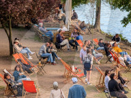 People Relax By The Riverbank In Prague