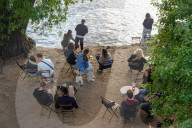 People Relax By The Riverbank In Prague