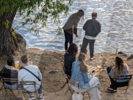 People Relax By The Riverbank In Prague