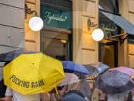 Crowd Waiting With Bold Yellow Umbrella