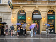 People Queue In Rain At A Famous Schnitzel Restaurant In Vienna