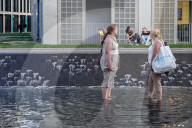 Women Cooling Off In Shallow Urban Fountain