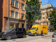 DHL Courier Delivering Packages With Electric Van