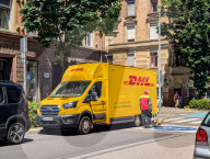 DHL Courier Delivering Packages With Electric Van