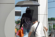 Woman Uses Umbrella For Shade During Heatwave