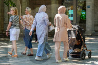 Women Walking With Baby Stroller In City Center