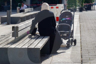Woman With Stroller On City Bench
