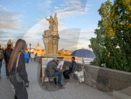 Tourists And Street Artists On Charles Bridge In Prague