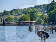 Young Man With Umbrella At Lakeside During Summer Heat