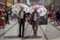 Gay Couple In Floral Suits With Parasols At Pride Parade