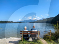 Senior Couple On A Bench By Lake