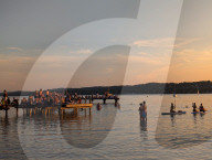 People Enjoy Summer Sunset At Lake