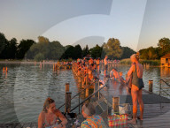 People Enjoy Summer Sunset At Lake