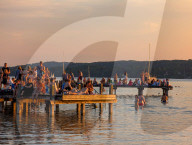 People Enjoy Summer Sunset At Lake