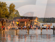 People Enjoy Summer Sunset At Lake
