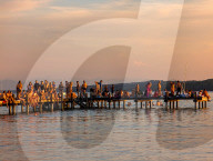 People Enjoy Summer Sunset At Lake